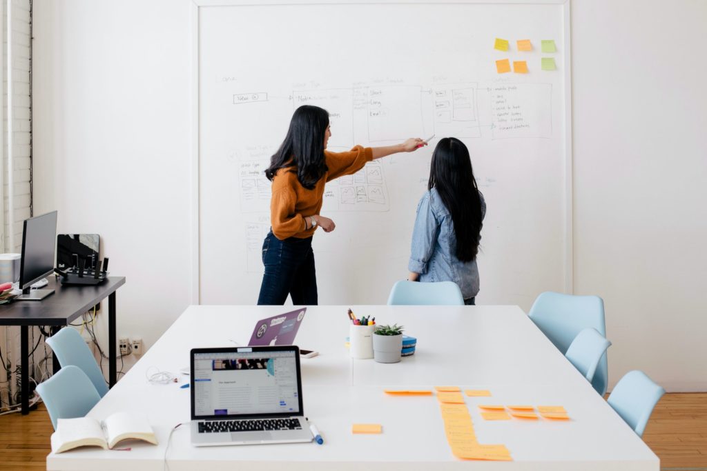 two women at white board