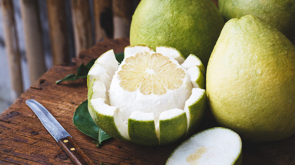 sliced pomelo fruit with knife