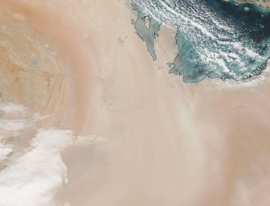 Aerial image demonstrating corrected reflectance in dust visibility. Clouds and a body of water are visible. 