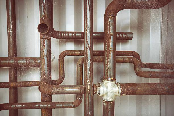 Image of a cluster of plumbing pipes. Two of them have been newly joined together by a cross pipe. 
